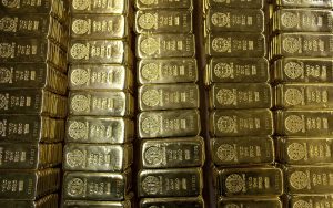 Gold down, poised for weekly gain